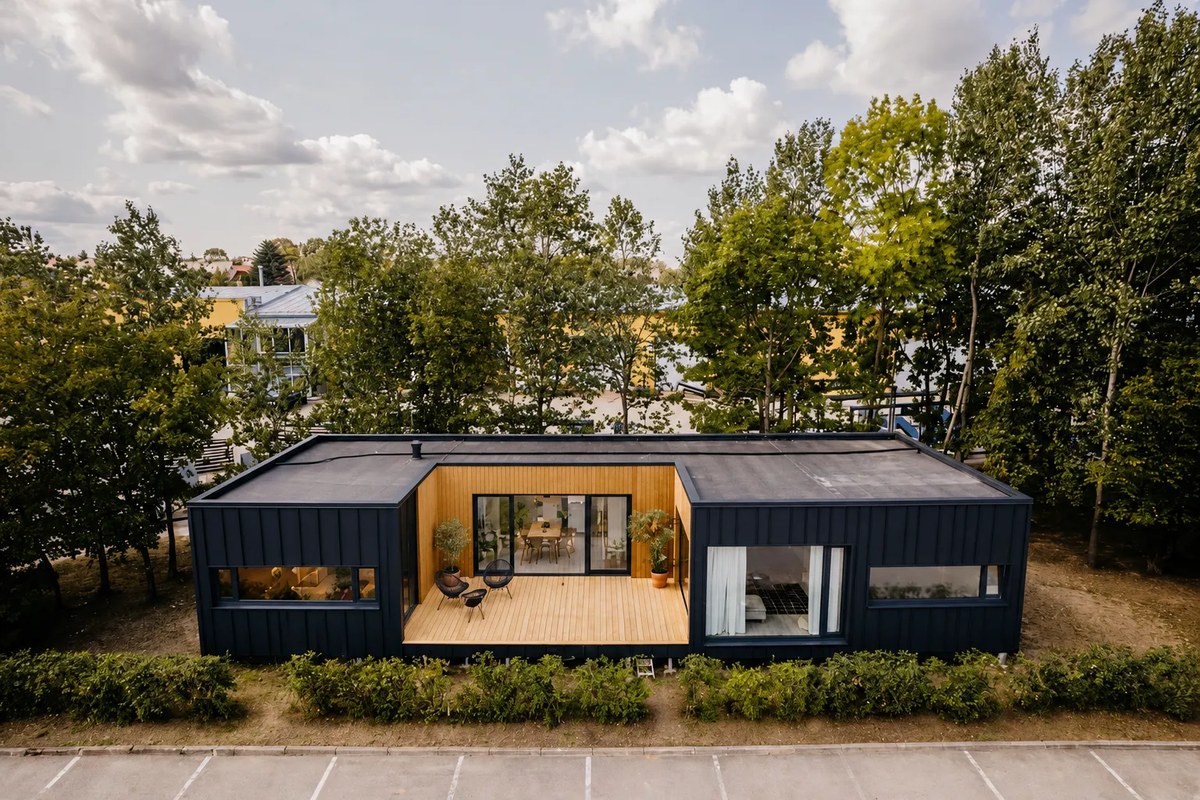 Ausgeführtes LE ModulHaus mit dunkler Fassade und holzverkleidetem Rücksprung